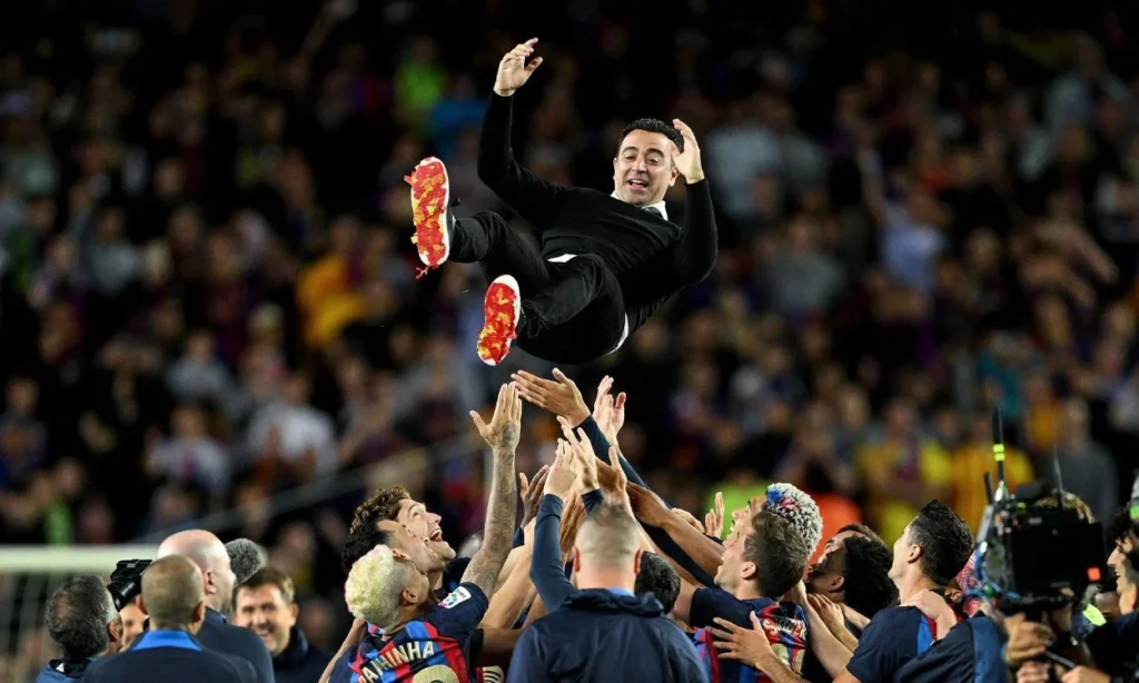 Xavi Hernandez being celebrated by his players