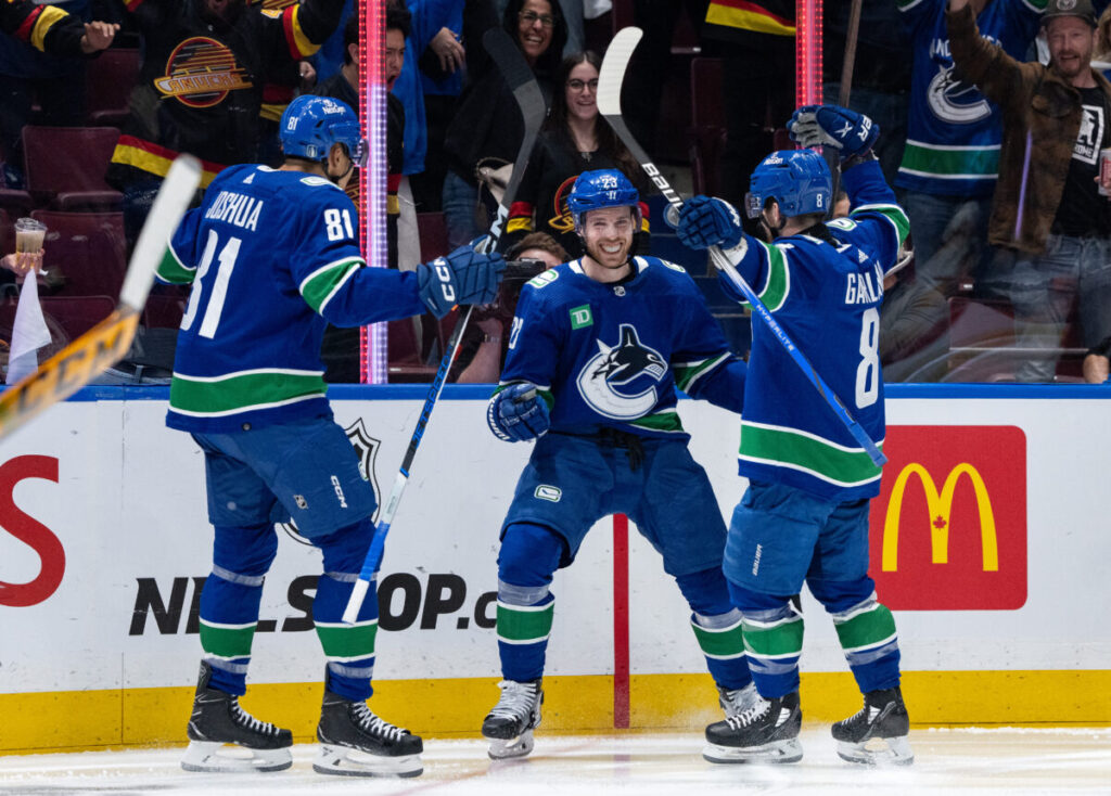 Dakota Joshua, Elias Lindholm, and Conor Garland of the Vancouver Canucks